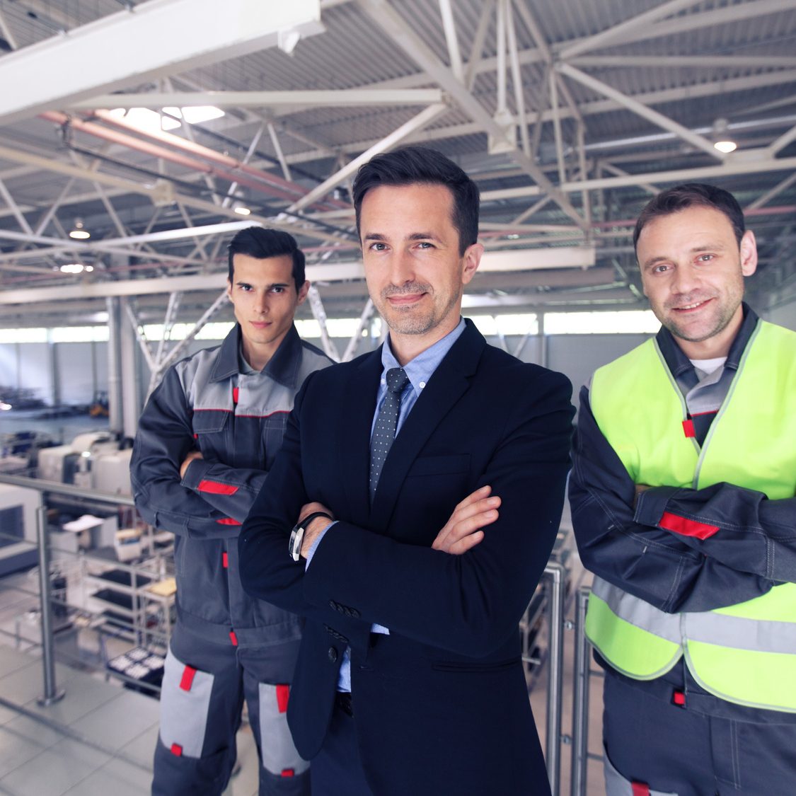 Manager and workers in factory Team of manager and two workers in CNC factory